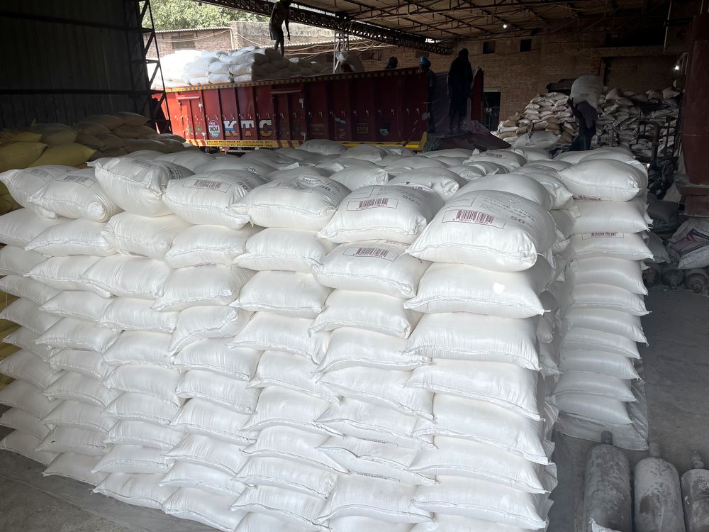 White flour sacks stacked high inside a shed