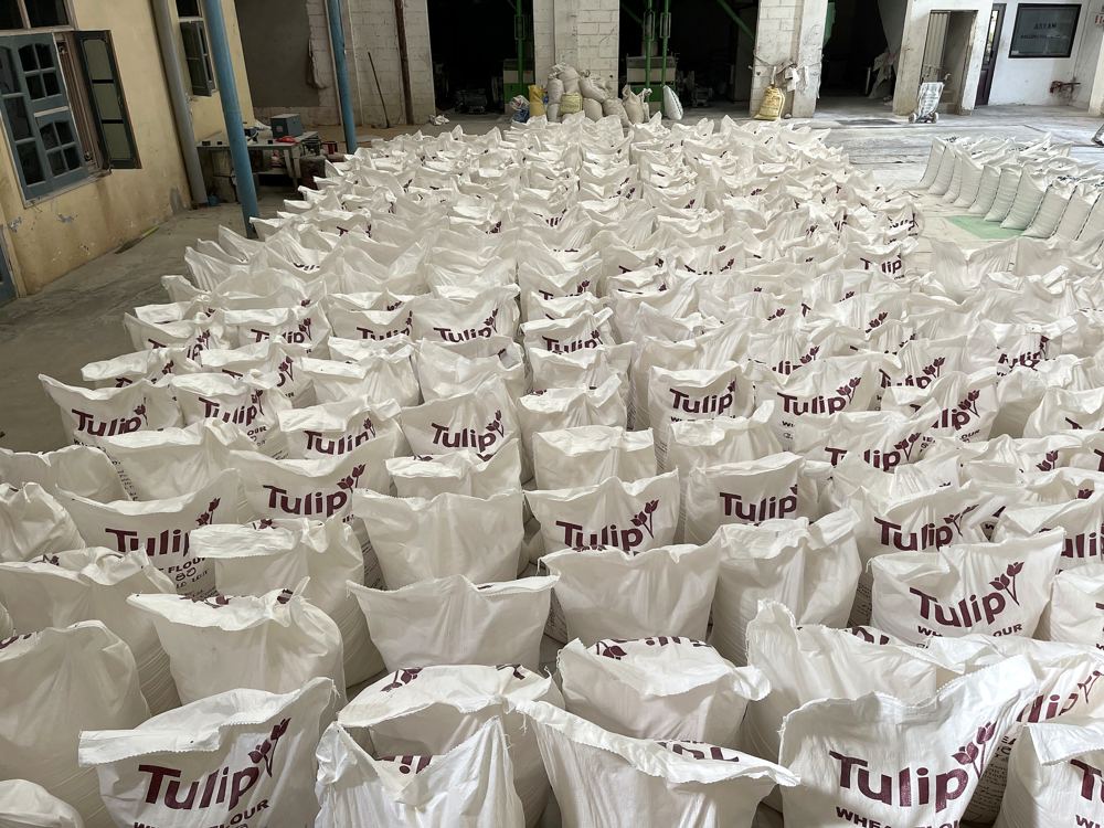 A mill floor covered with rows of filled wheat flour sacks