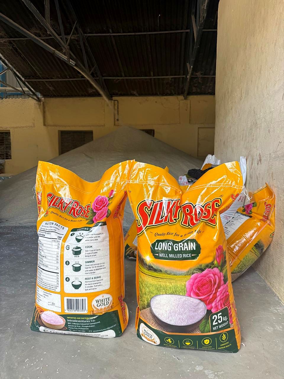 Front and back of a printed 25 kg long-grain rice bag, with a heap of rice behind